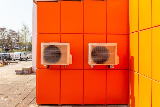 Two air compressors installation on orange wall outside