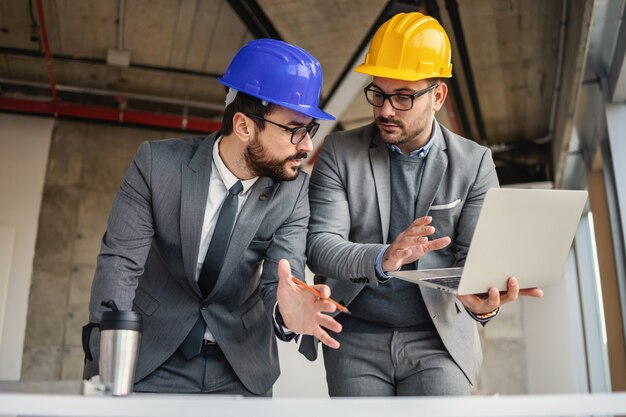 Two architect in building in construction process talking and brainstorming about innovations in their project.