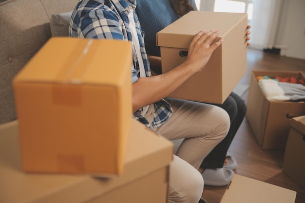 two asian blogger showing clothes in front of the camera to recording vlog video live streaming at her shop online shopping cart notion on sofa at home