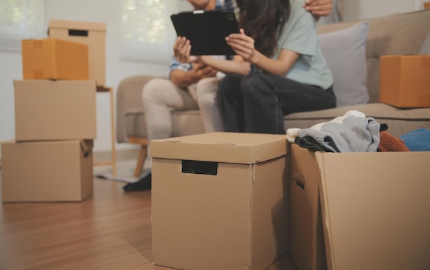 Two Asian blogger showing clothes in front of the camera to recording vlog video live streaming at her shop Online Shopping Cart notion on sofa at home