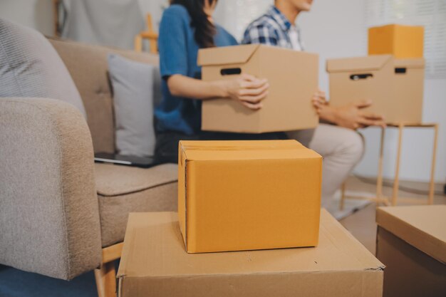 two asian blogger showing clothes in front of the camera to recording vlog video live streaming at her shop online shopping cart notion on sofa at home