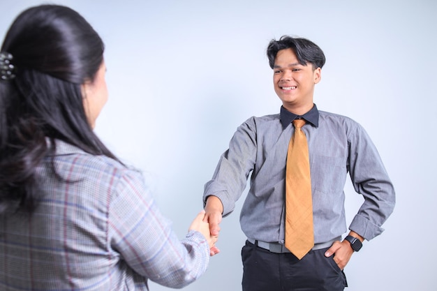 Foto due uomini d'affari asiatici che si stringono la mano dal punto di vista della spalla