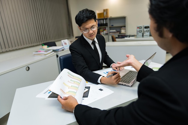 2人のアジア人ビジネスマンが会社のビジネスについて話し合う2人が仕事のストレスとより深刻なことについて話している