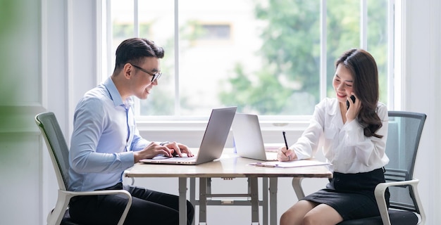 Two Asian businesspeople working at office