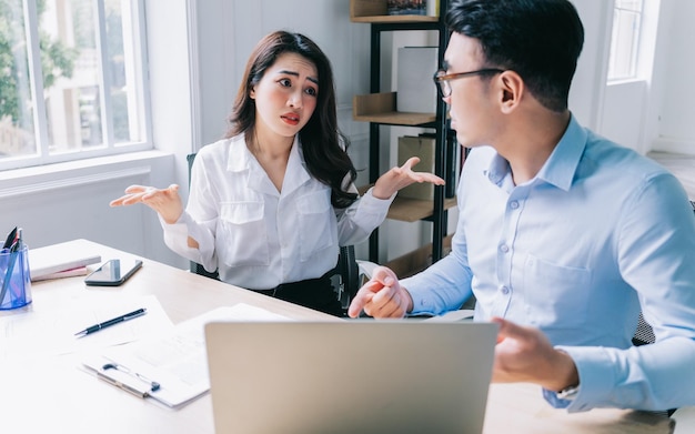 Two Asian businesspeople working at office