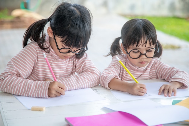 写真 家で一緒に宿題をしている2人のアジアの子供たち