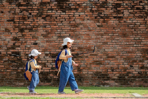 Two Asian children girls are bloggers. Broadcast on the Internet. Record vlog and blog subscribers. Record video lessons for Internet. Use camera with tripod.