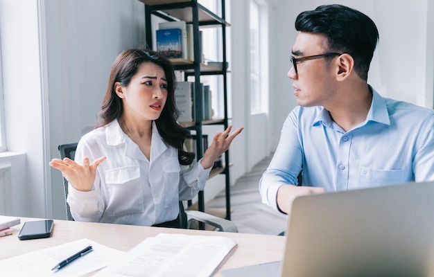 two asian colleagues are having a heated argument with each other