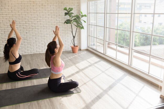 Yoga di formazione di due amici asiatici