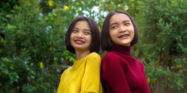 Две азиатские счастливые молодые девушки на природе