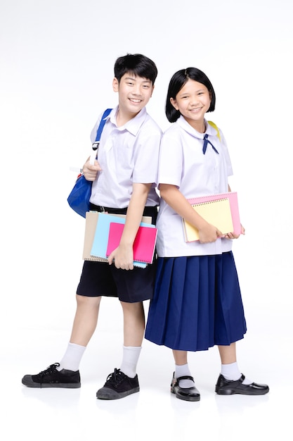 Two asian smiling school kids with colorful stationery,