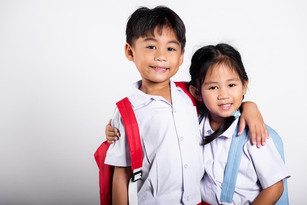 Two Asian student kid girl boy schoolchildren brother sister smile happy wear student thai uniform red pants skirt hug each other