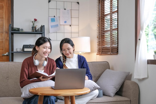 Two asian students learning together online with a laptop and tutor together at home