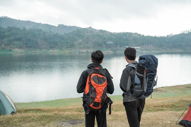 Two asian travelers standing near lake