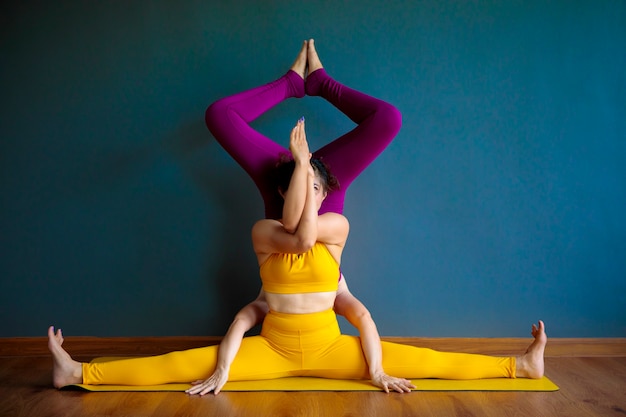 Two asian woman doing yoga pose in home living room