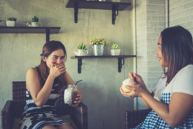 Две азиатки говорят о шутке в кофейне