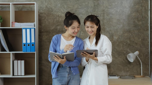 Две азиатские женщины в чате Деловые женщины беседуют в конференц-зале Молодые предприниматели управляют стартапом Молодая и энергичная группа управляет компанией Концепция стартап-компании