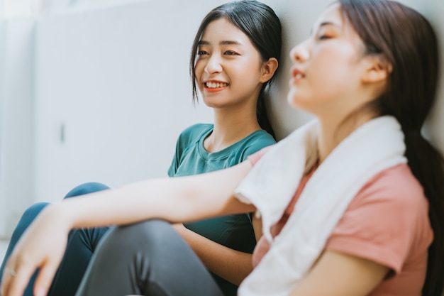 Two Asian women taking a break from yoga session