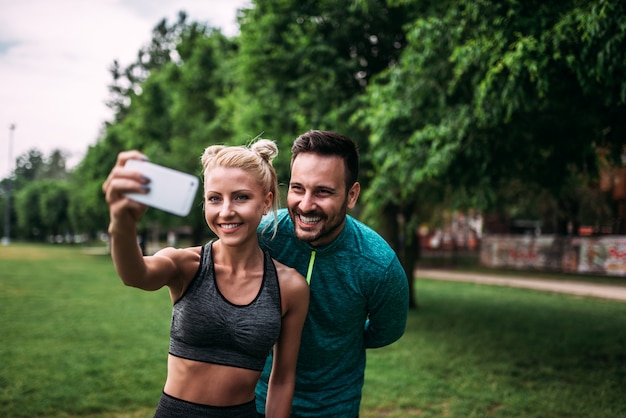 Два спортсмена, делая selfie в парке.