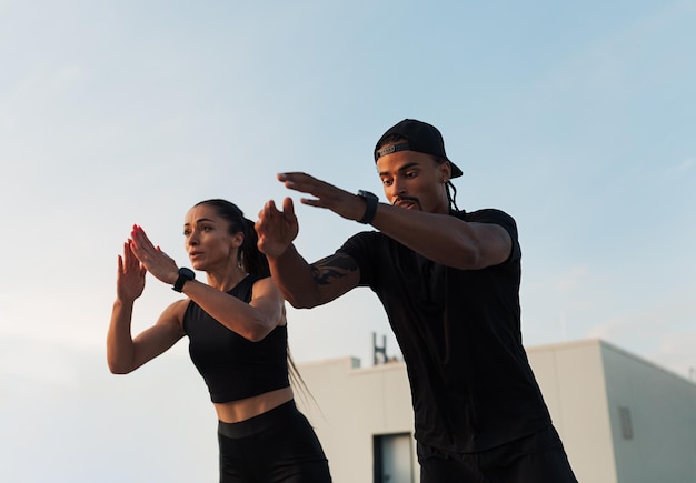 Photo two athletes jumping together outdoors on the roof