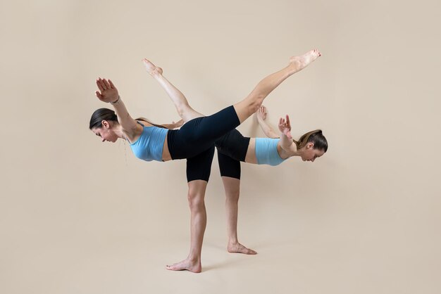 two athletic caucasian women in sportswear doing fitness yoga or pilates exercises isolated