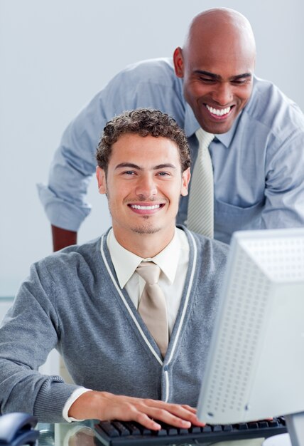 Two attractive businessmen working at a computer