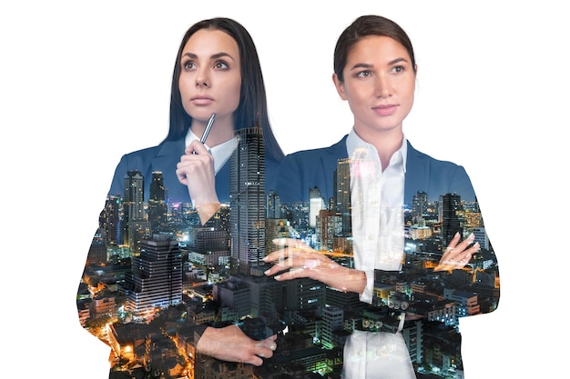 Two attractive businesswomen in suits crossed arms pose Asia corporate lifestyle multinational diverse young professionals Night Bangkok city view Double exposure