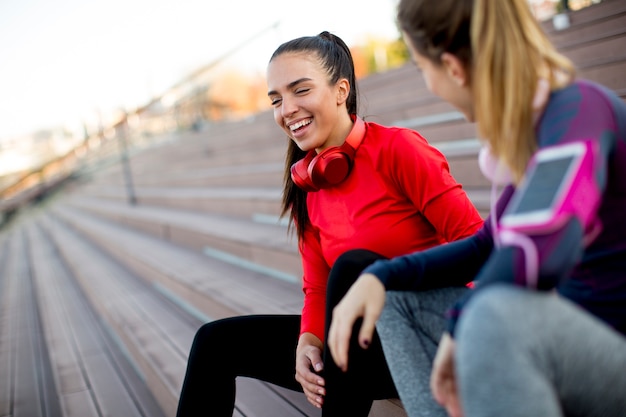 Two attractive female runner taking break after jogging outdoors