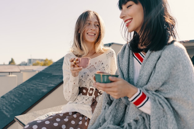 Two attractive girls enjoy a tea party