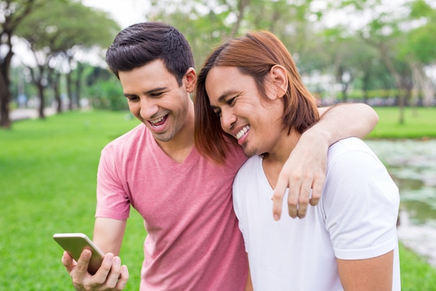 Two Attractive Men Using Smartphone and Laughing