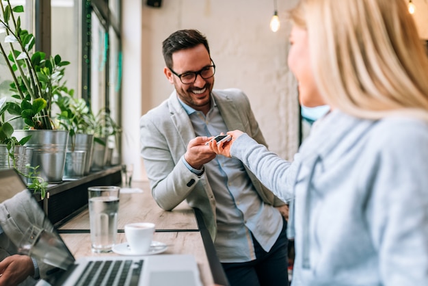 Due giovani attraenti che scambiano i numeri di telefono al caffè.