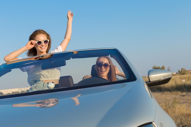 Two attractive young women in a cabriolet car