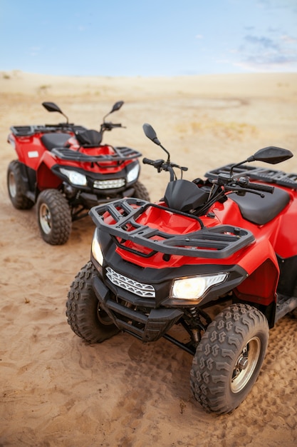 Photo two atvs in desert, quadbikes closeup, nobody. quad bike, sandy race, dune safari in hot sunny day, 4x4 extreme adventure, quad-biking