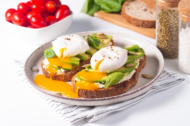 写真 アボカドのオープンサンド2個と卵。ケトとダイエットのコンセプト。朝食にヘルシーなトースト。