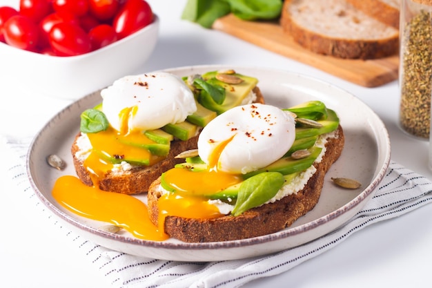 Due panini aperti all'avocado con l'uovo. keto e concetto di dieta. cibo sano per toast a colazione.