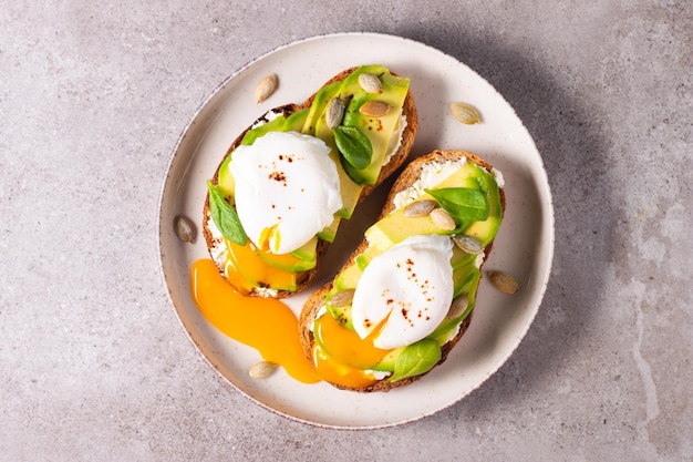 Two avocado open sandwiches with egg. Keto and diet concept. Healthy toast food for breakfast.