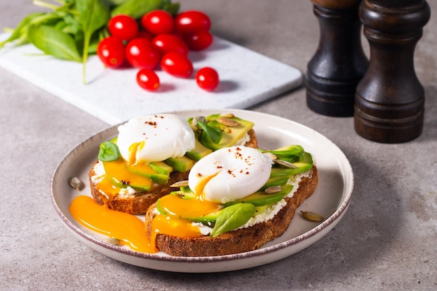 Two avocado open sandwiches with egg. Keto and diet concept. Healthy toast food for breakfast.