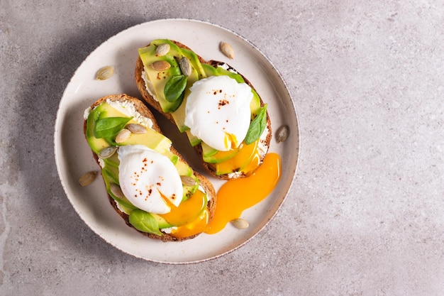 Foto due panini aperti all'avocado con l'uovo. keto e concetto di dieta. cibo sano per toast a colazione.