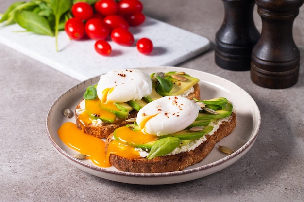 Photo two avocado open sandwiches with egg. keto and diet concept. healthy toast food for breakfast.