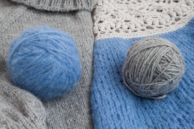 Two balls of yarn for knitting lie on a knitted cloth.