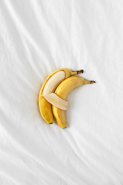 Two bananas lie side by side and hug each other like people.