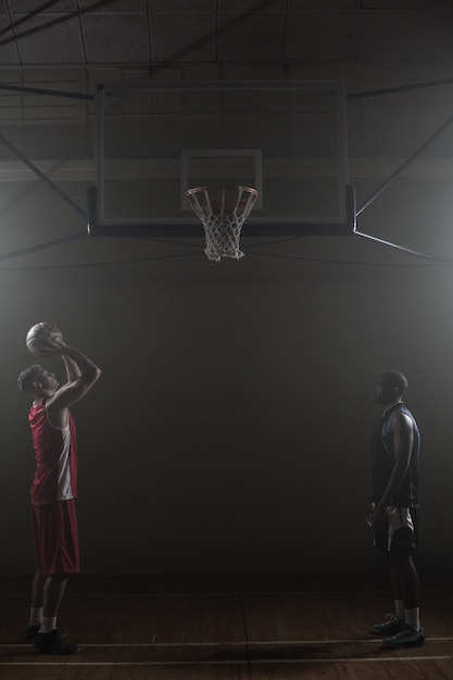 Two basketball player with one scoring a shoot