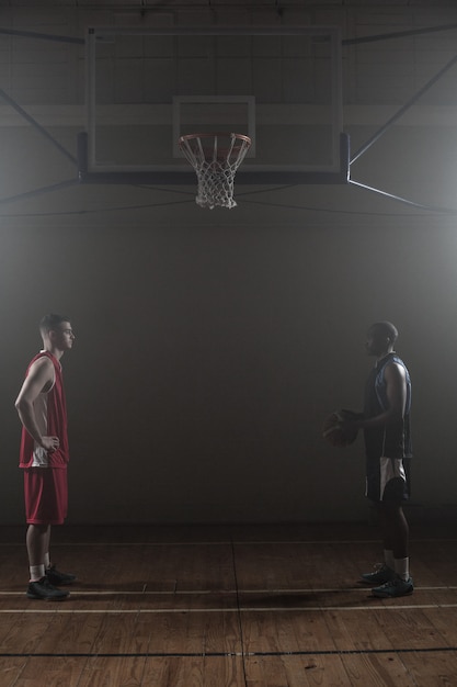 Two basketball rival looking each other face to face