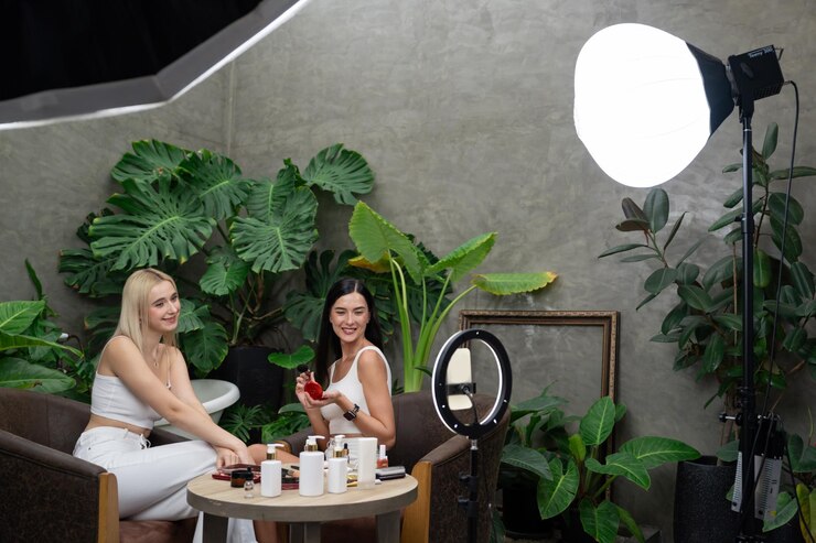 Photo two beautiful content creator making natural beauty and cosmetic tutorial on green plant garden video beauty blogger showing how to beauty care to social medial audience using selfie stick blithe