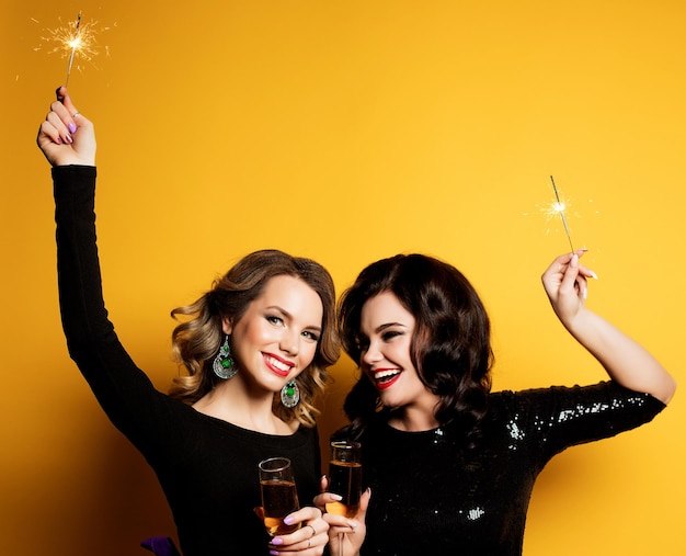 Two beautiful elegant women celebrate party and drinking champagne