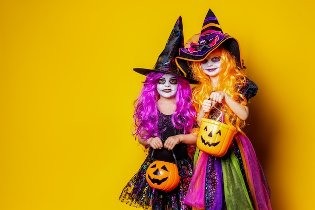 Two beautiful girl in a witch costume scaring and making faces