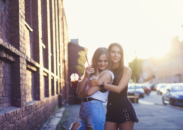 Photo two beautiful girls with drinks