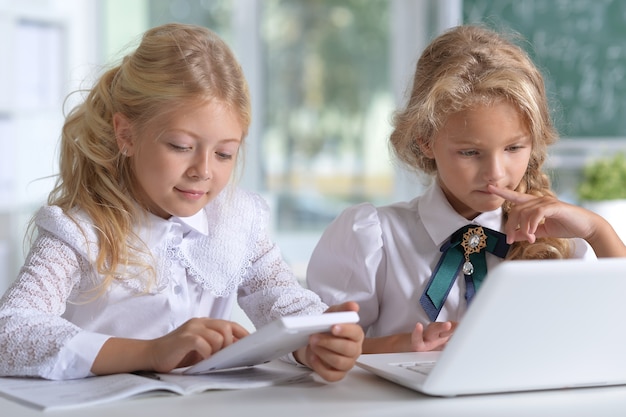 Due belle bambine in classe con il laptop