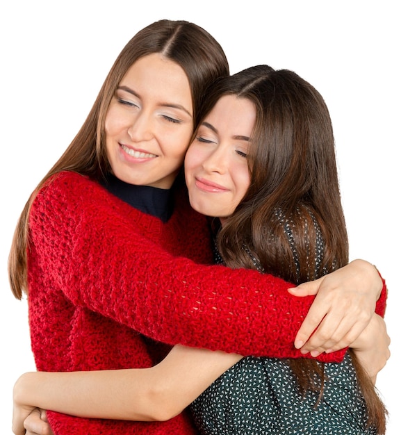 Two beautiful sisters hugging each other and smiling