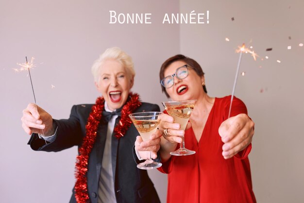 Two beautiful stylish mature senior women celebrating new year Fun party style celebration conce